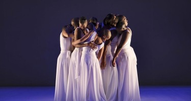 Dada Masilo's The Sacrifice Publicity photo shoot at The Dance Factory in Newtown, Johannesburg. South Africa. 06 March 2020Eight Black women with shaved heads and long white dresses stands grouped together holding each otheron a stage. Photograph: John Hogg